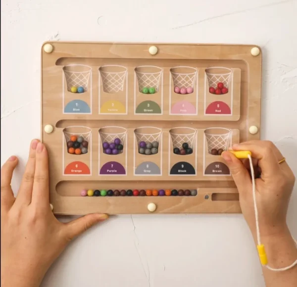 A person holding a board with many different colored beads.