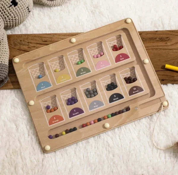 A wooden tray with many different colored beads.