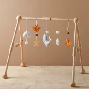 A wooden baby play gym with hanging toys.