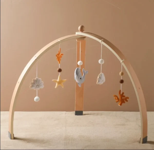 A wooden baby mobile with hanging decorations.