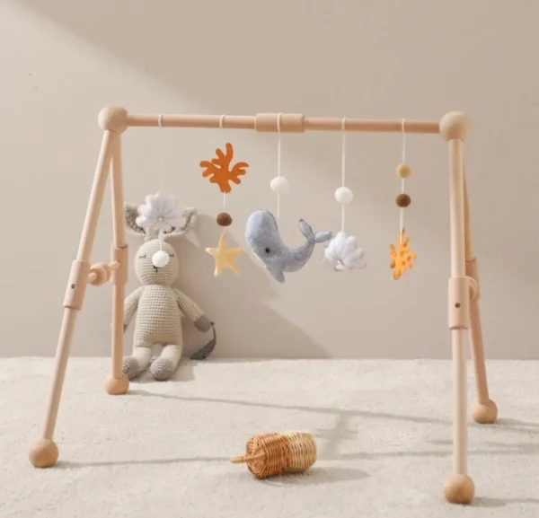 A wooden baby play gym with stuffed animals