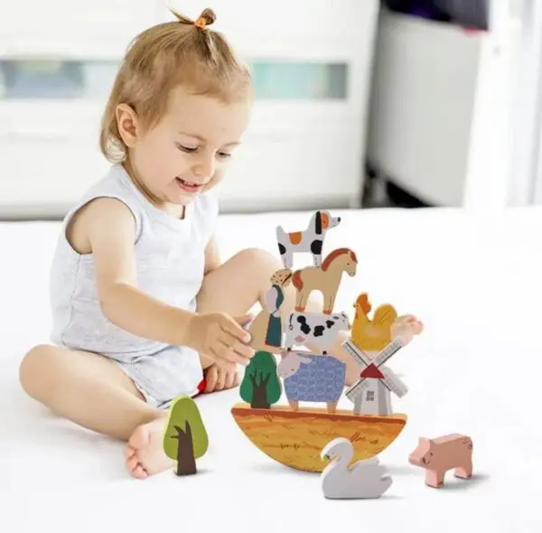 A child playing with wooden toys on the bed