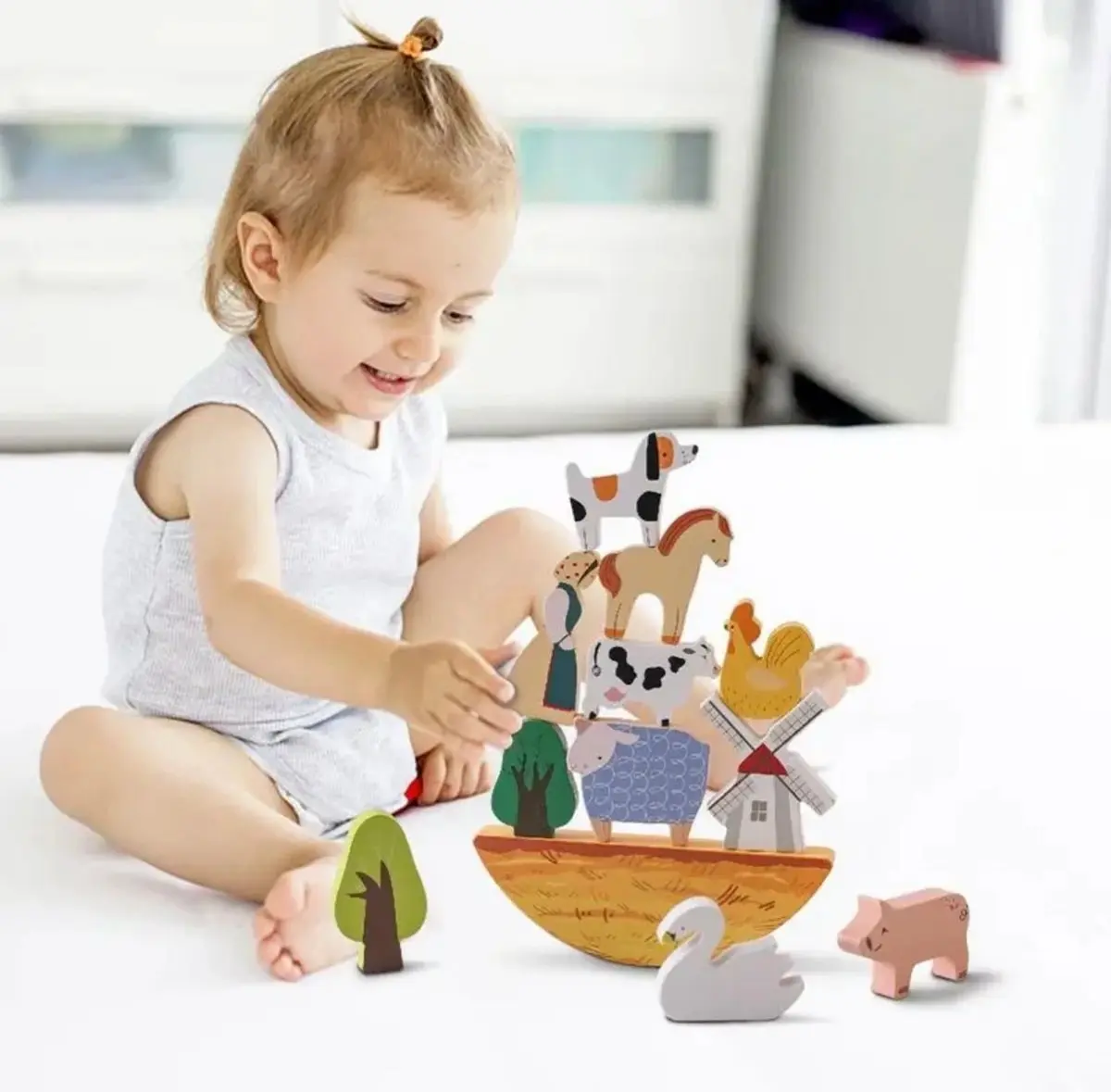 A child playing with wooden toys on the bed