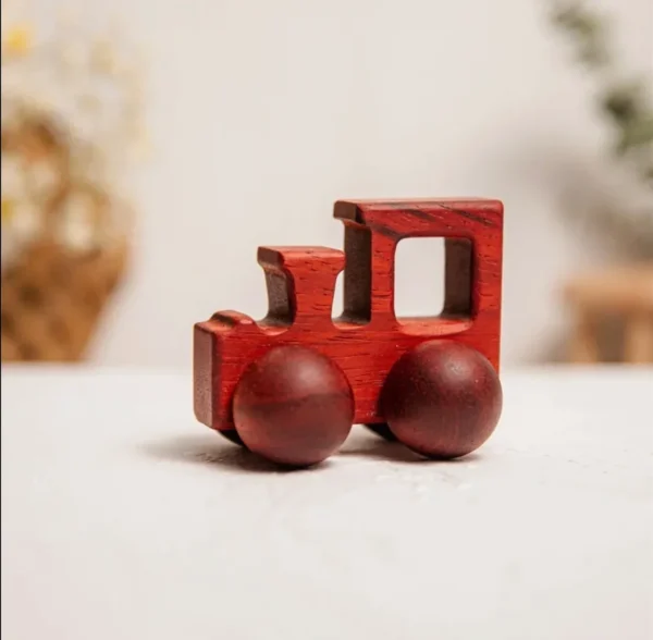 A red toy train is sitting on the table.