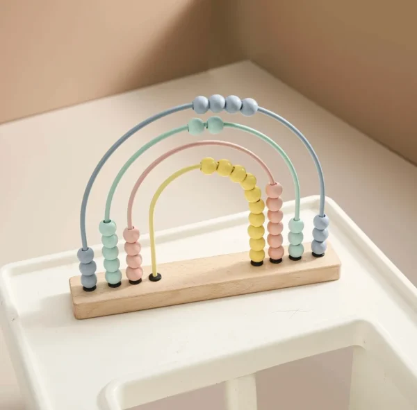 A wooden toy with beads and an arch.