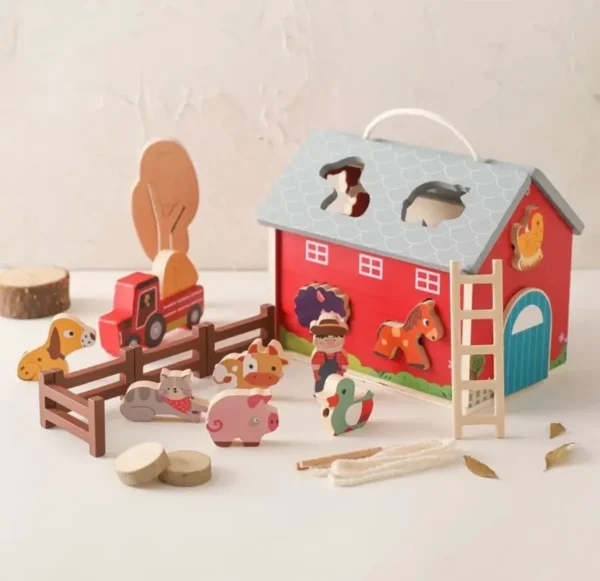 A wooden toy set of a barn and farm.