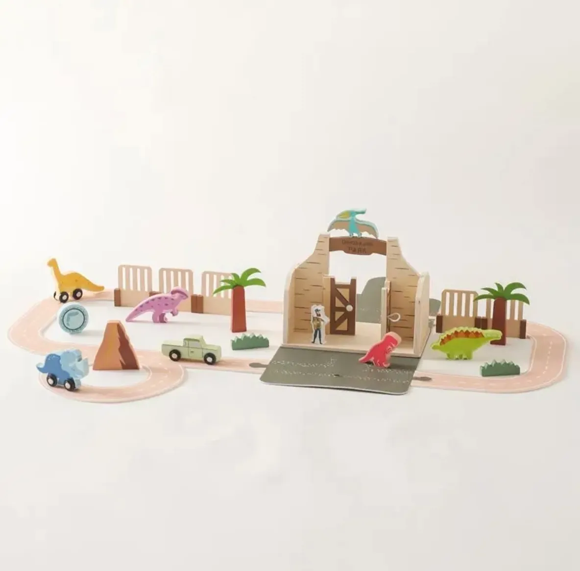 A wooden toy set of dinosaurs and trees.