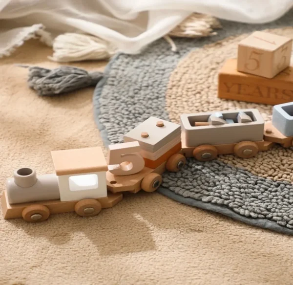 A wooden toy train on the floor of a room.