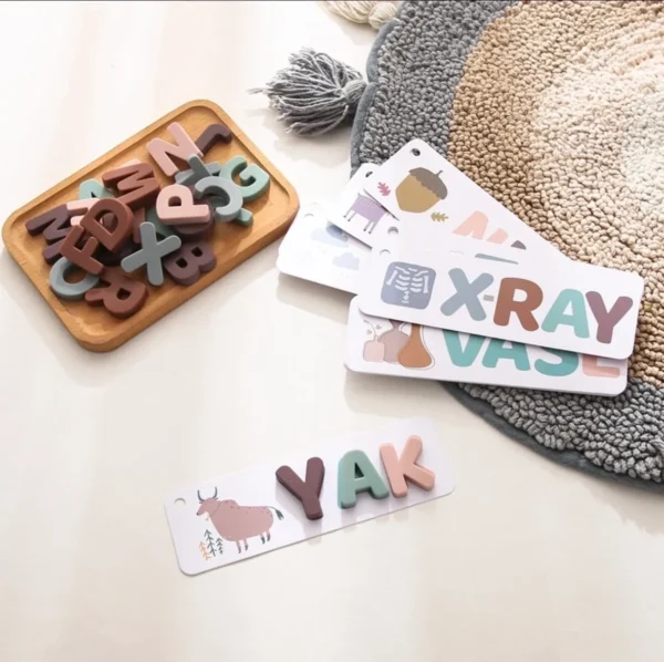 A wooden tray with letters and a rug on the floor.