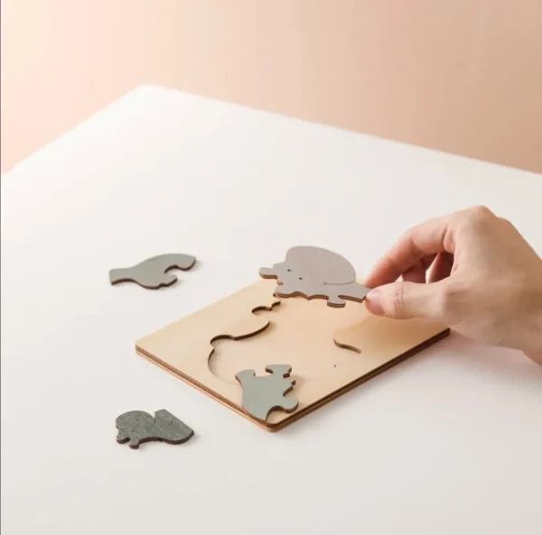 A person is playing with a puzzle on the table.