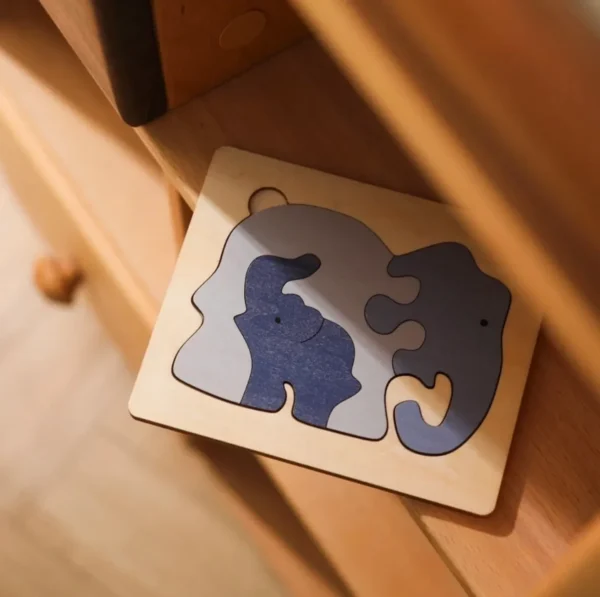 A wooden puzzle with two elephants on it.