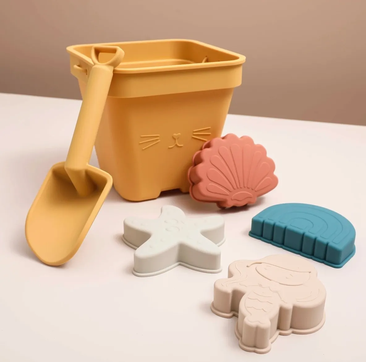 A yellow bucket and some other toys on the table.