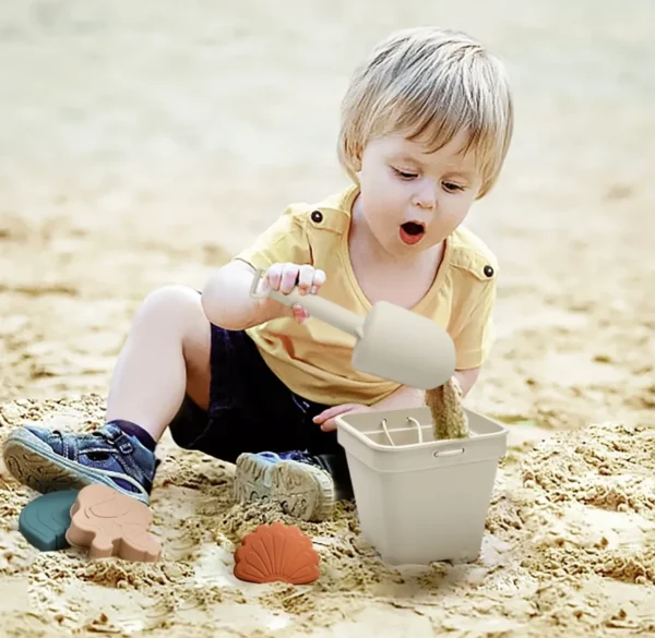 A young child playing with sand and toys.