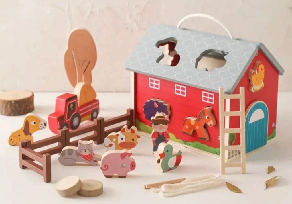 A wooden toy barn with many different animals.